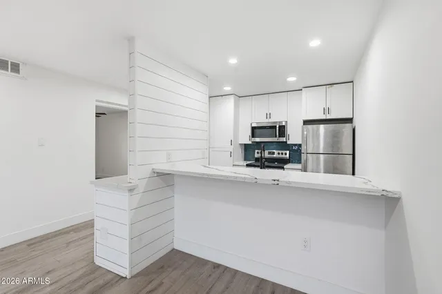 a kitchen with stainless steel appliances a refrigerator and a stove top oven