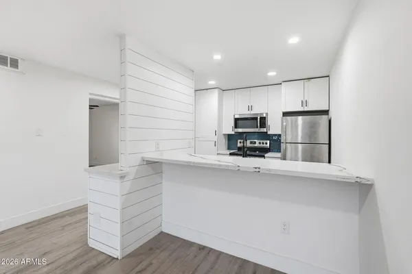 a kitchen with stainless steel appliances a refrigerator and a stove top oven