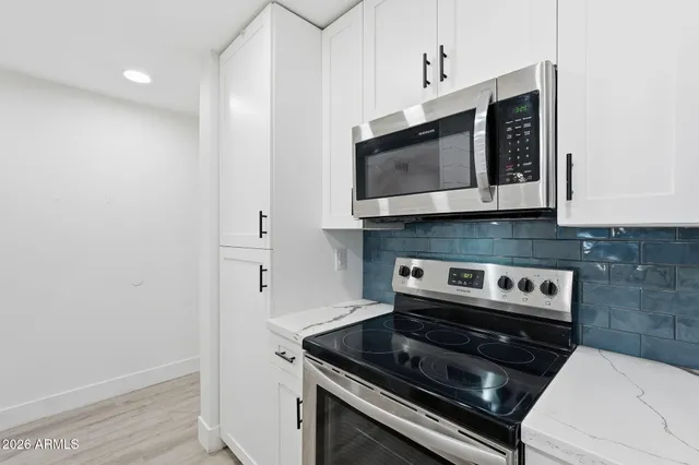 a kitchen with stainless steel appliances white cabinets and stove