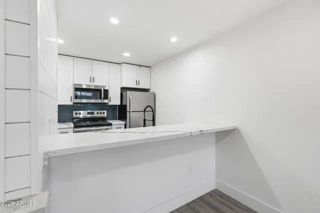 a kitchen with stainless steel appliances a refrigerator and a stove top oven