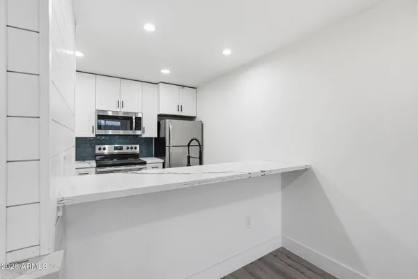 a kitchen with stainless steel appliances a refrigerator and a stove top oven