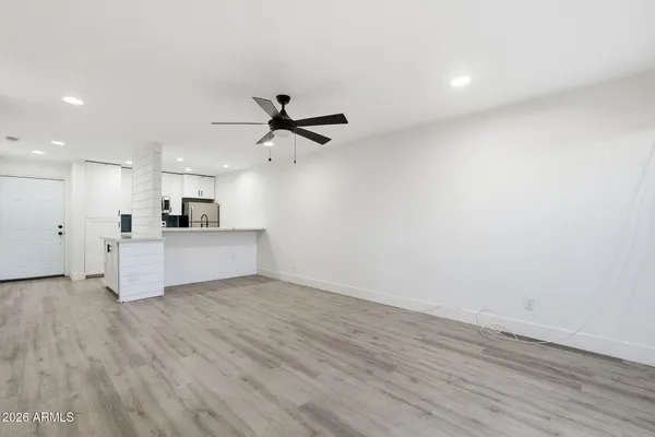 a view of a kitchen with a sink a ceiling fan and stainless steel appliances