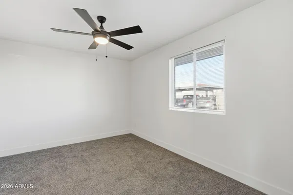 an empty room with a window and a ceiling fan