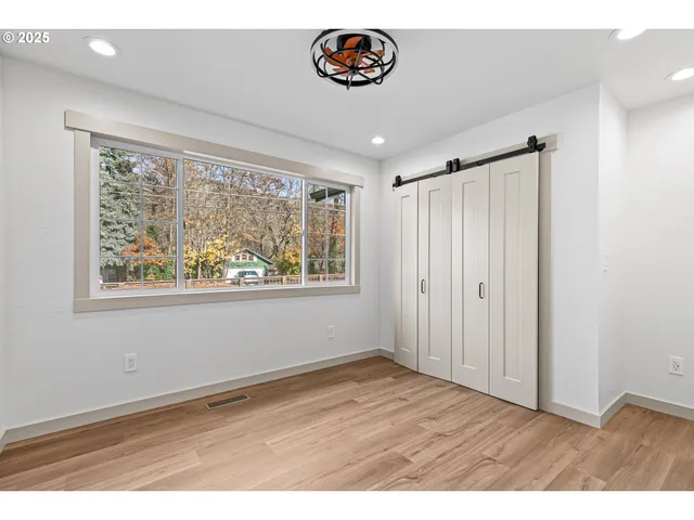 a room with wooden floor and windows