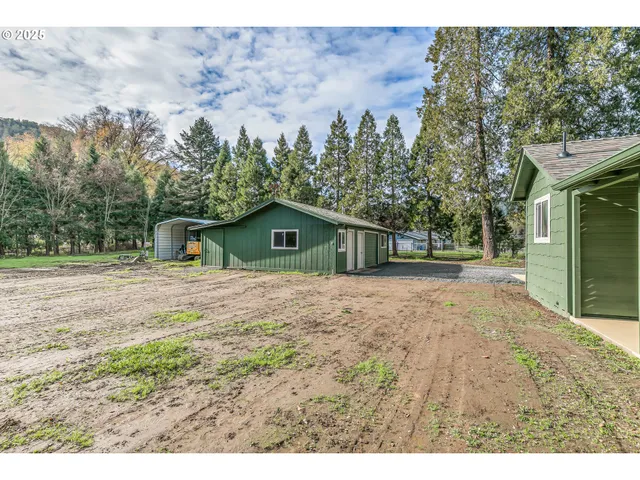 a view of a big house with a big yard and large trees