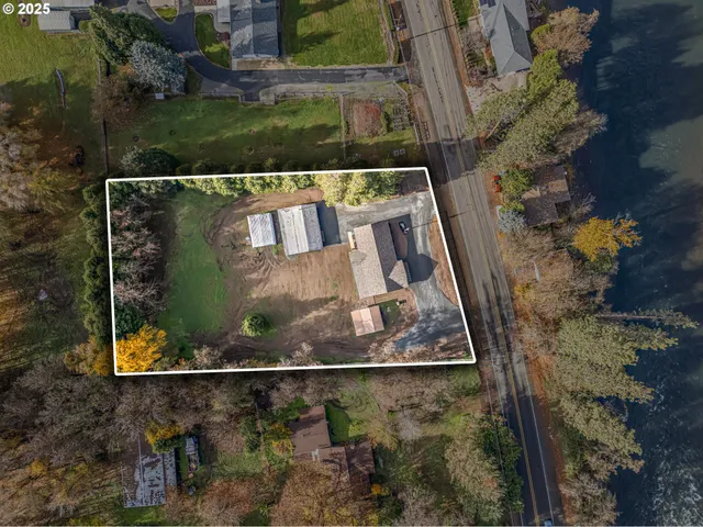 an aerial view of a house with a garden and lake view