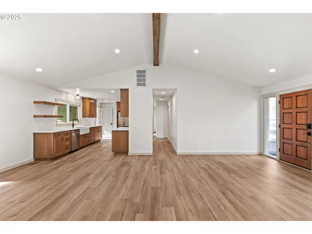 a view of a kitchen with stainless steel appliances a refrigerator and wooden floor