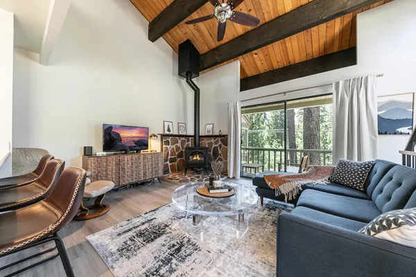 a living room with furniture large window and flat screen tv