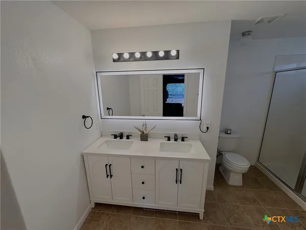 a bathroom with a sink toilet and mirror