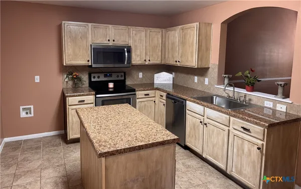 a kitchen with granite countertop a stove and a sink