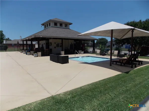 a view of patio with chairs and table under an umbrella