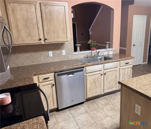a kitchen with stainless steel appliances granite countertop a sink stove and cabinets