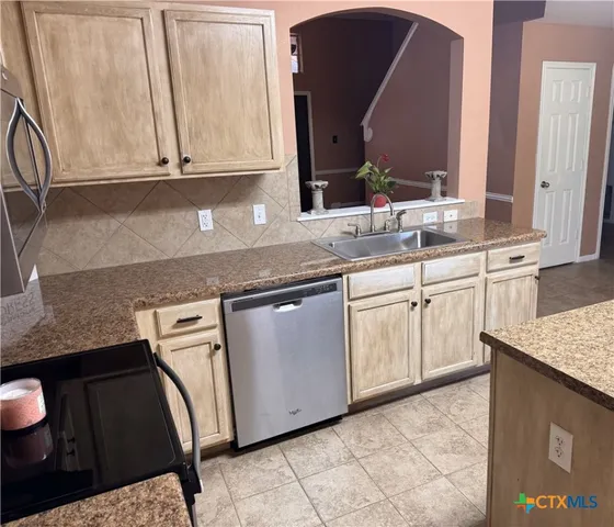 an empty room with a chandelier fan and windows