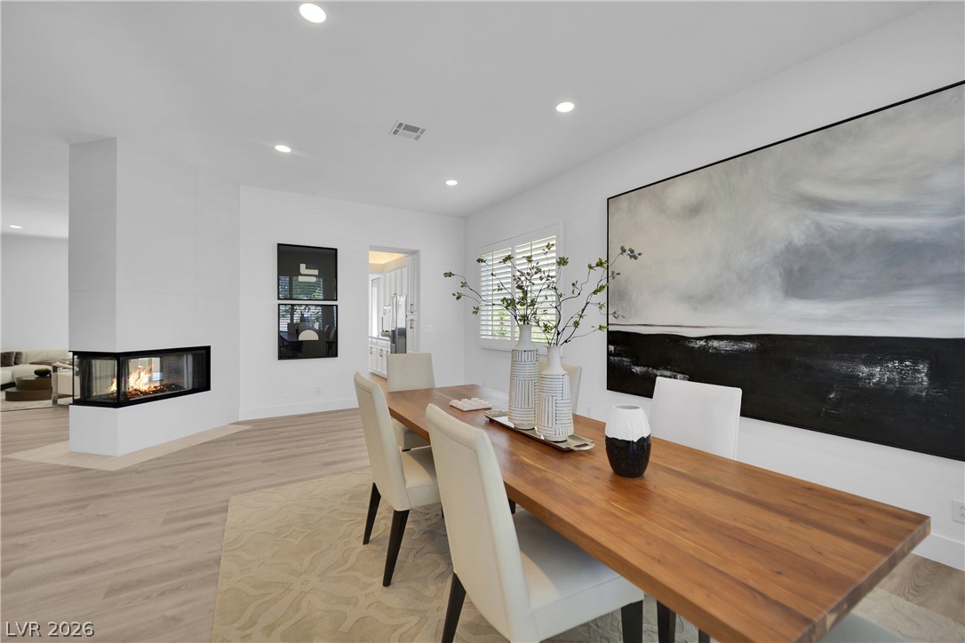 8981 Rivers Edge Drive Las Vegas, NV 89117 - Photo 8 of 69 A modern, open dining area showcases sleek hardwood flooring and a stylish fireplace.