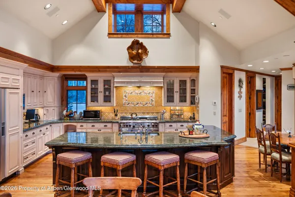 a dining table with chairs and view kitchen