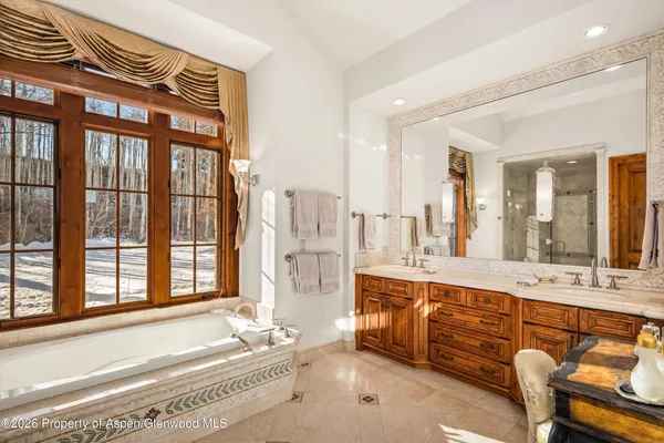 a spacious bathroom with a tub sink and mirror