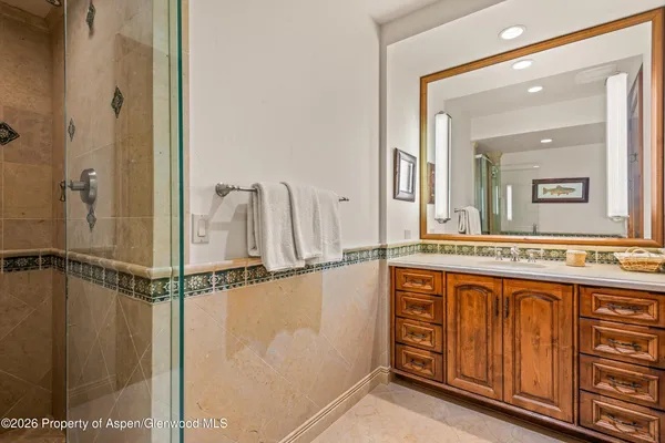 a bathroom with a sink and mirror with bathtub