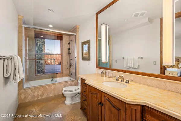 a spacious bathroom with a shower sink and mirror