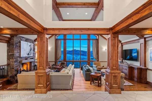 a living room with fireplace furniture and a large window