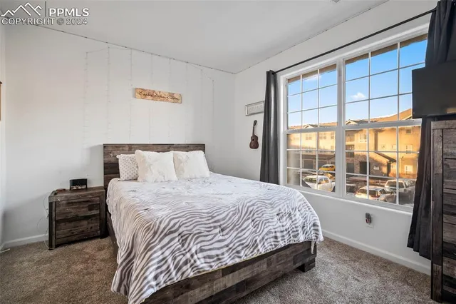 a bedroom with a bed and a large window