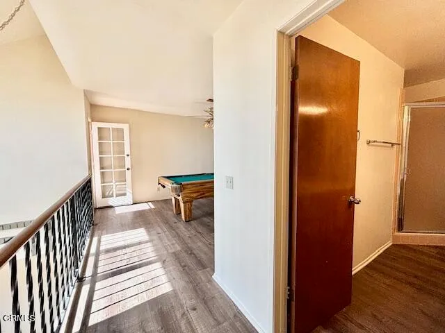a view of a hallway with wooden floor and staircase