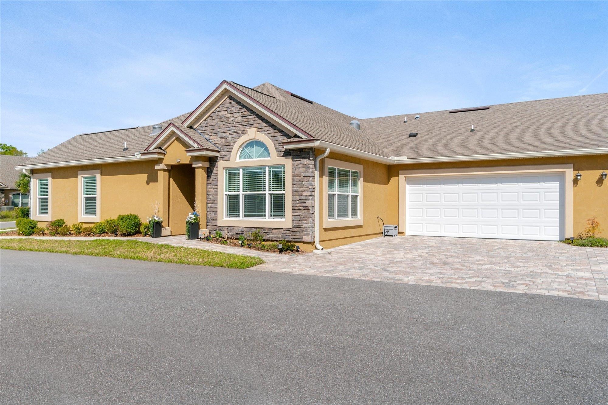 a view of a house with a yard and large parking space