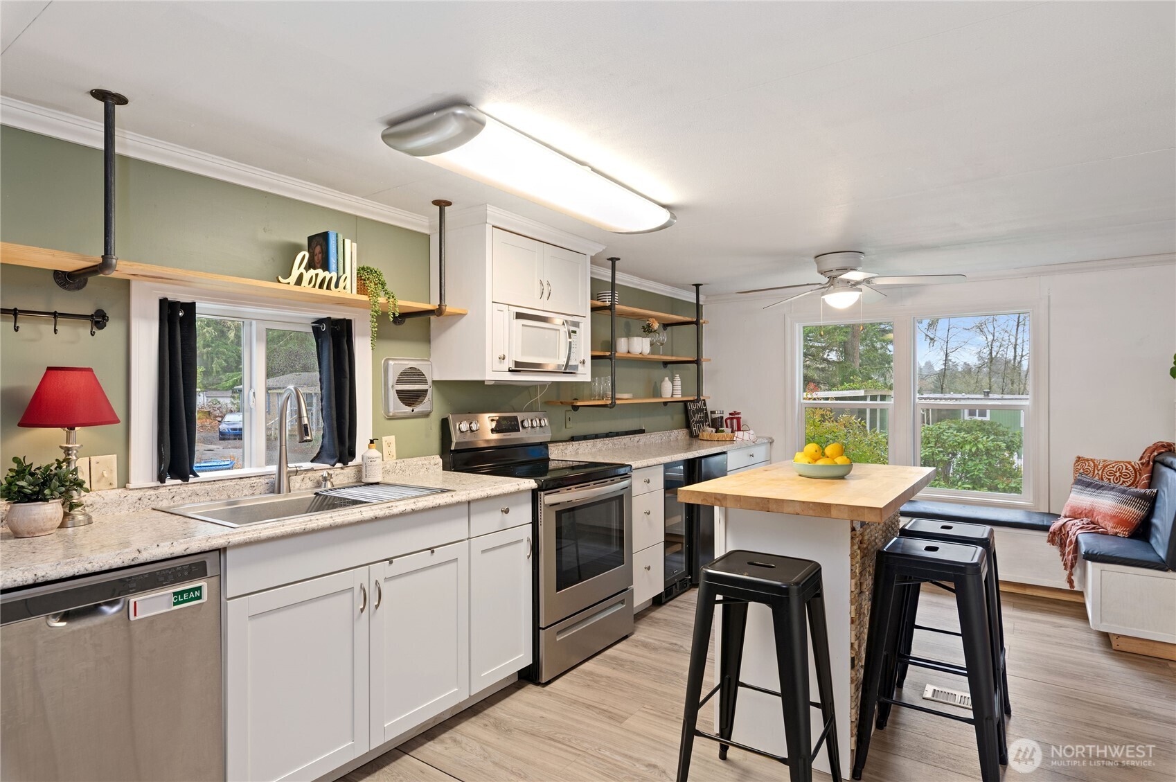 3060 Northeast McWilliams Road, Unit 52 Bremerton, WA 98311 - Photo 12 of 27 a kitchen with stainless steel appliances granite countertop a stove a sink dishwasher a dining table and chairs with wooden floor