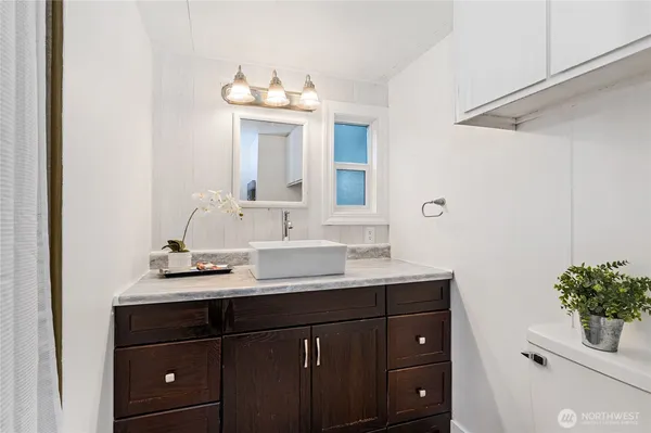 a bathroom with a sink vanity granite and a mirror