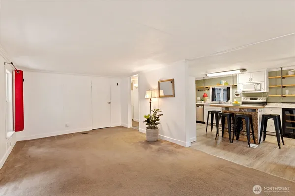 a view of an empty room with furniture and a kitchen