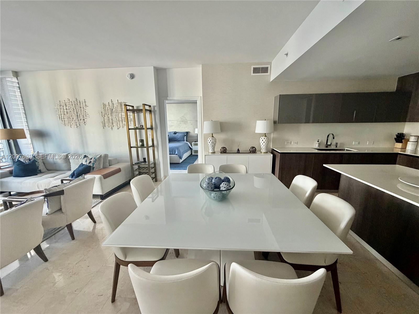 88 Southwest 7th Street, Unit 1109 Miami, FL 33130 - Photo 13 of 40 a kitchen with a table chairs stove and kitchen island