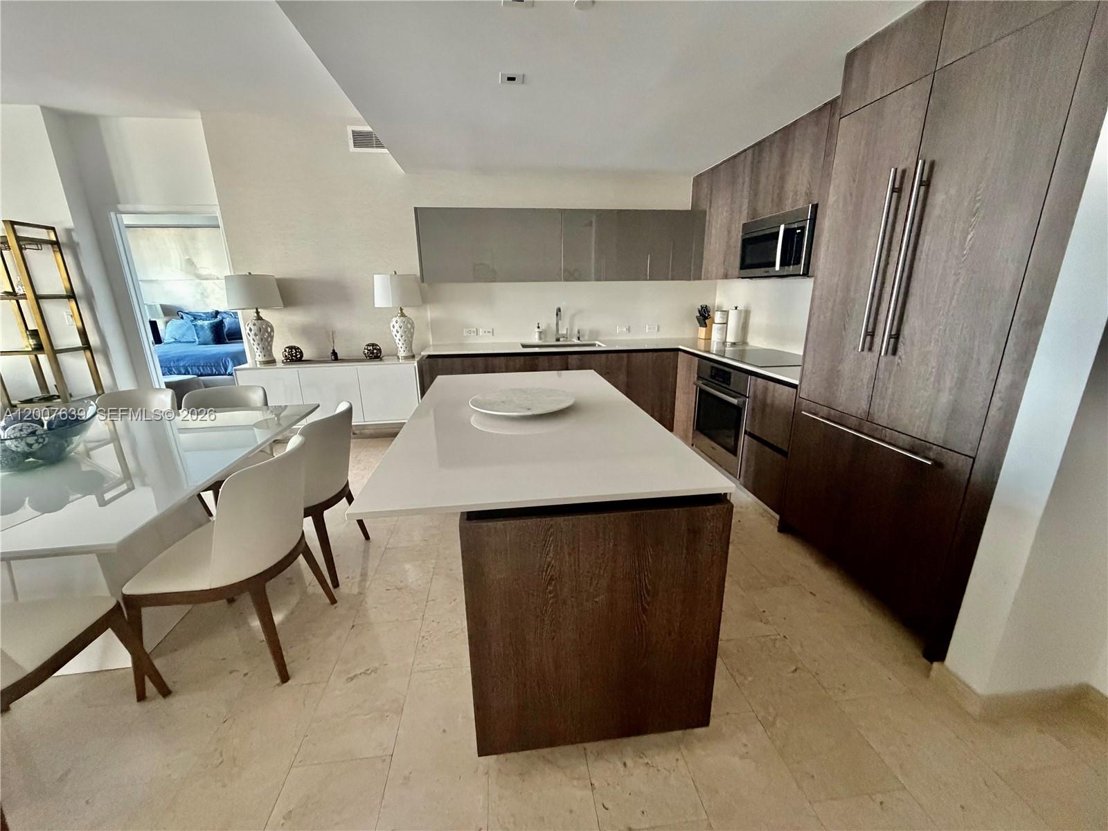 88 Southwest 7th Street, Unit 1109 Miami, FL 33130 - Photo 16 of 40 a kitchen with kitchen island a counter top space appliances and a center island