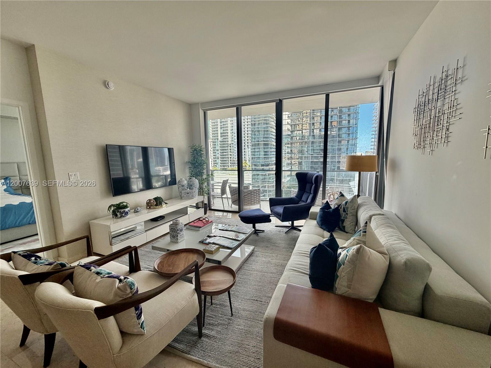 88 Southwest 7th Street, Unit 1109 Miami, FL 33130 - Photo 19 of 40 a living room with furniture large window and a flat screen tv