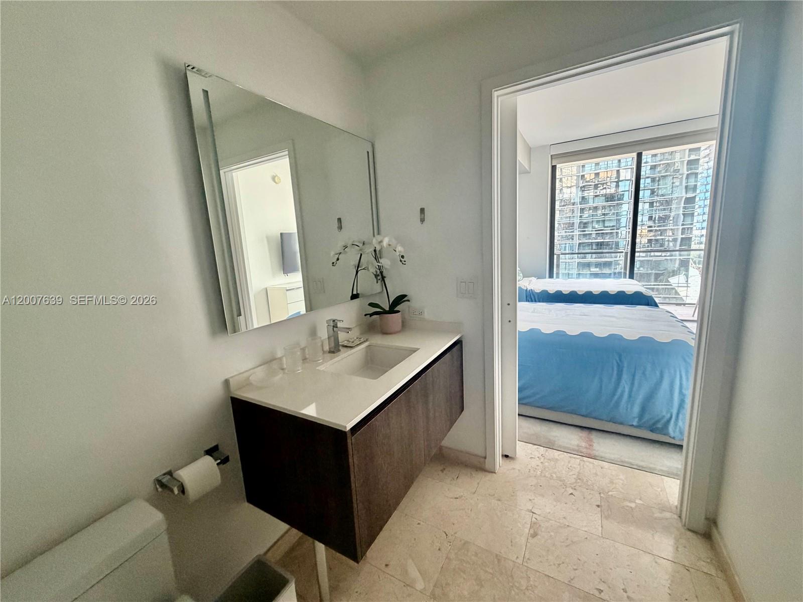 88 Southwest 7th Street, Unit 1109 Miami, FL 33130 - Photo 21 of 40 a bathroom with a sink a vanity and a mirror