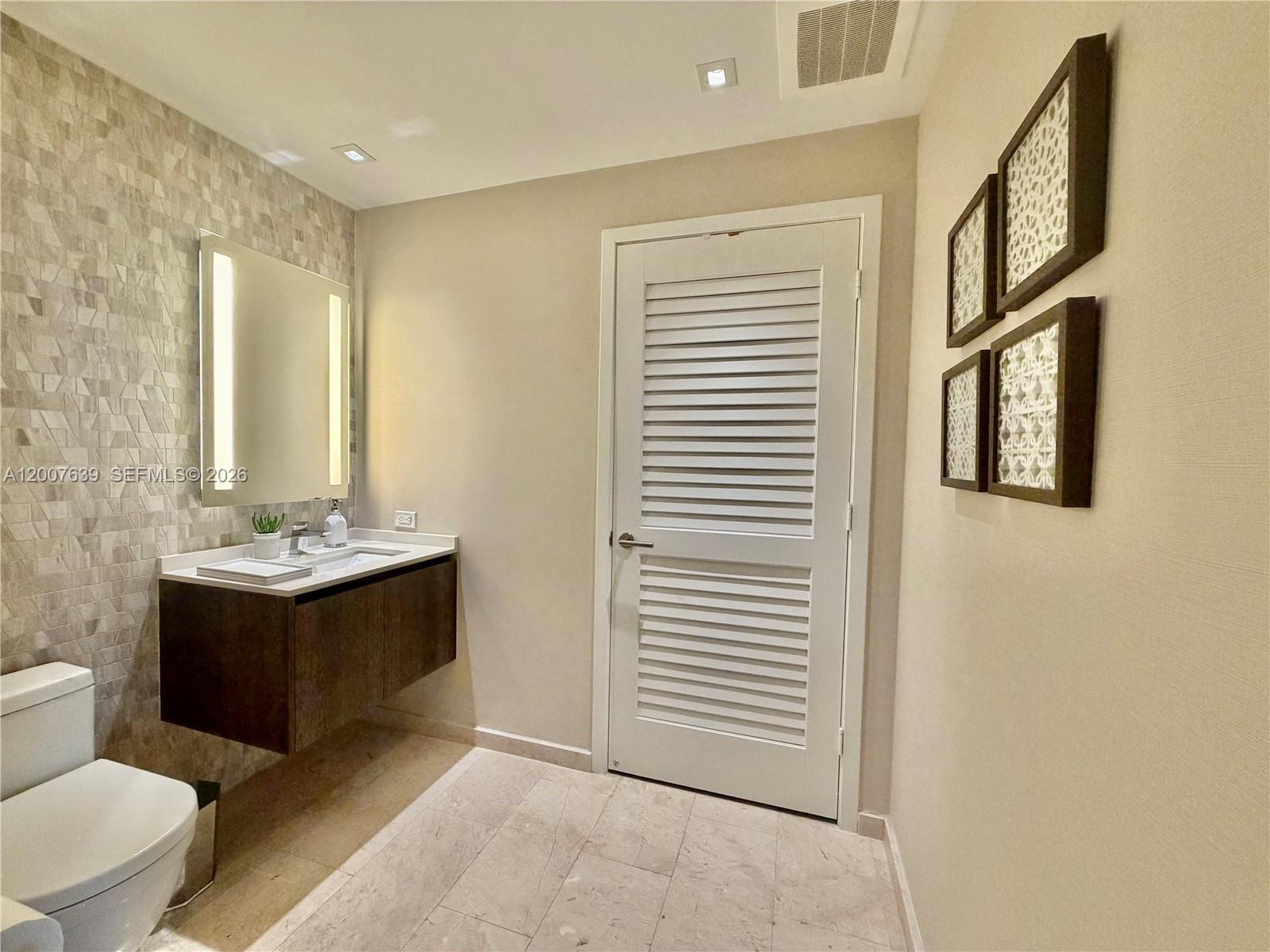 88 Southwest 7th Street, Unit 1109 Miami, FL 33130 - Photo 28 of 40 a bathroom with a sink and a mirror