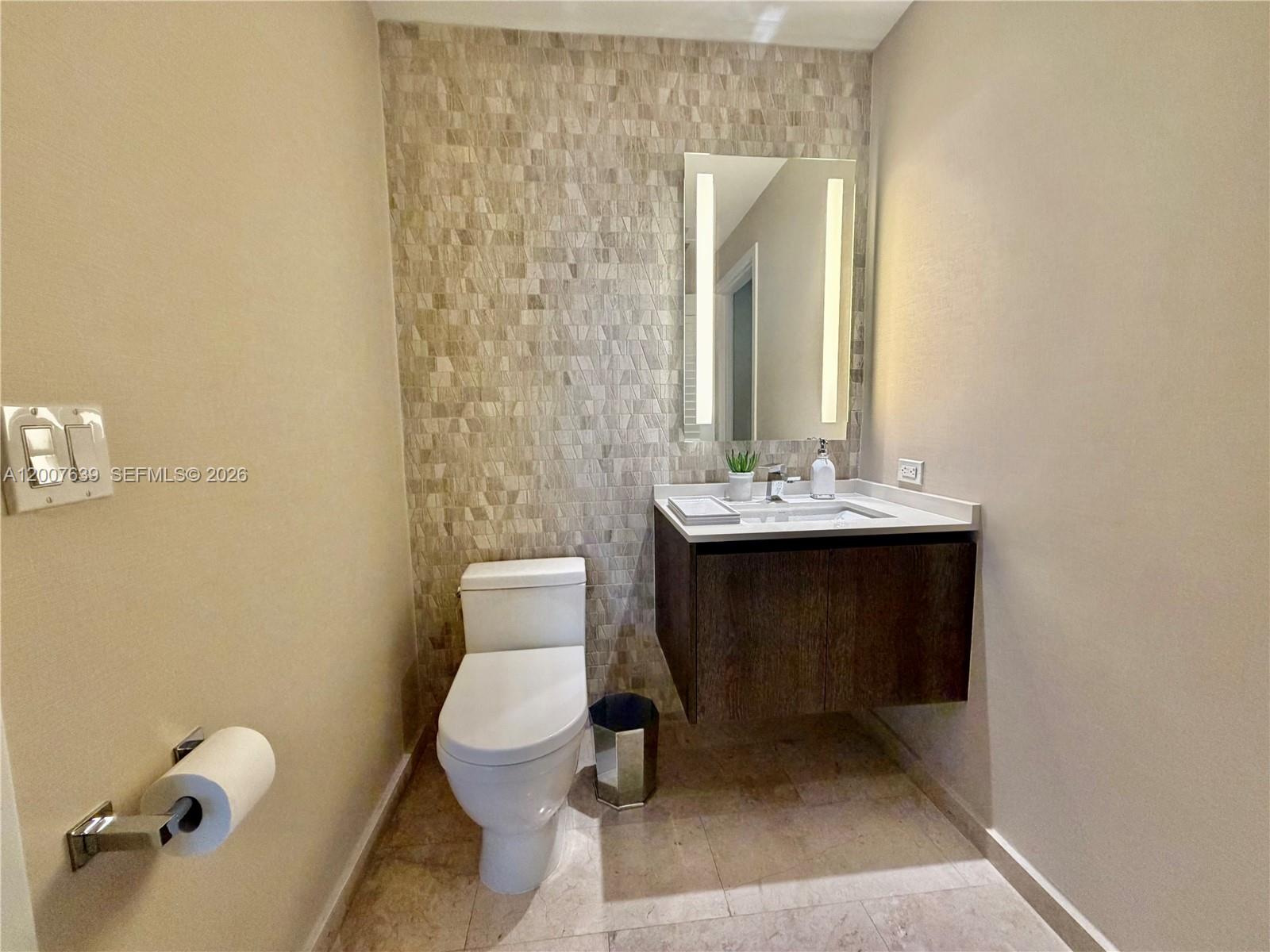 88 Southwest 7th Street, Unit 1109 Miami, FL 33130 - Photo 29 of 40 a bathroom with a toilet sink and mirror