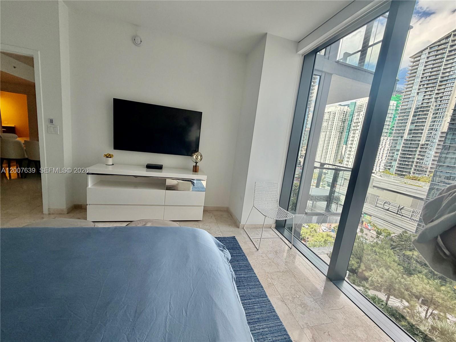 88 Southwest 7th Street, Unit 1109 Miami, FL 33130 - Photo 31 of 40 a view of a living room with a flat tv screen and a balcony view