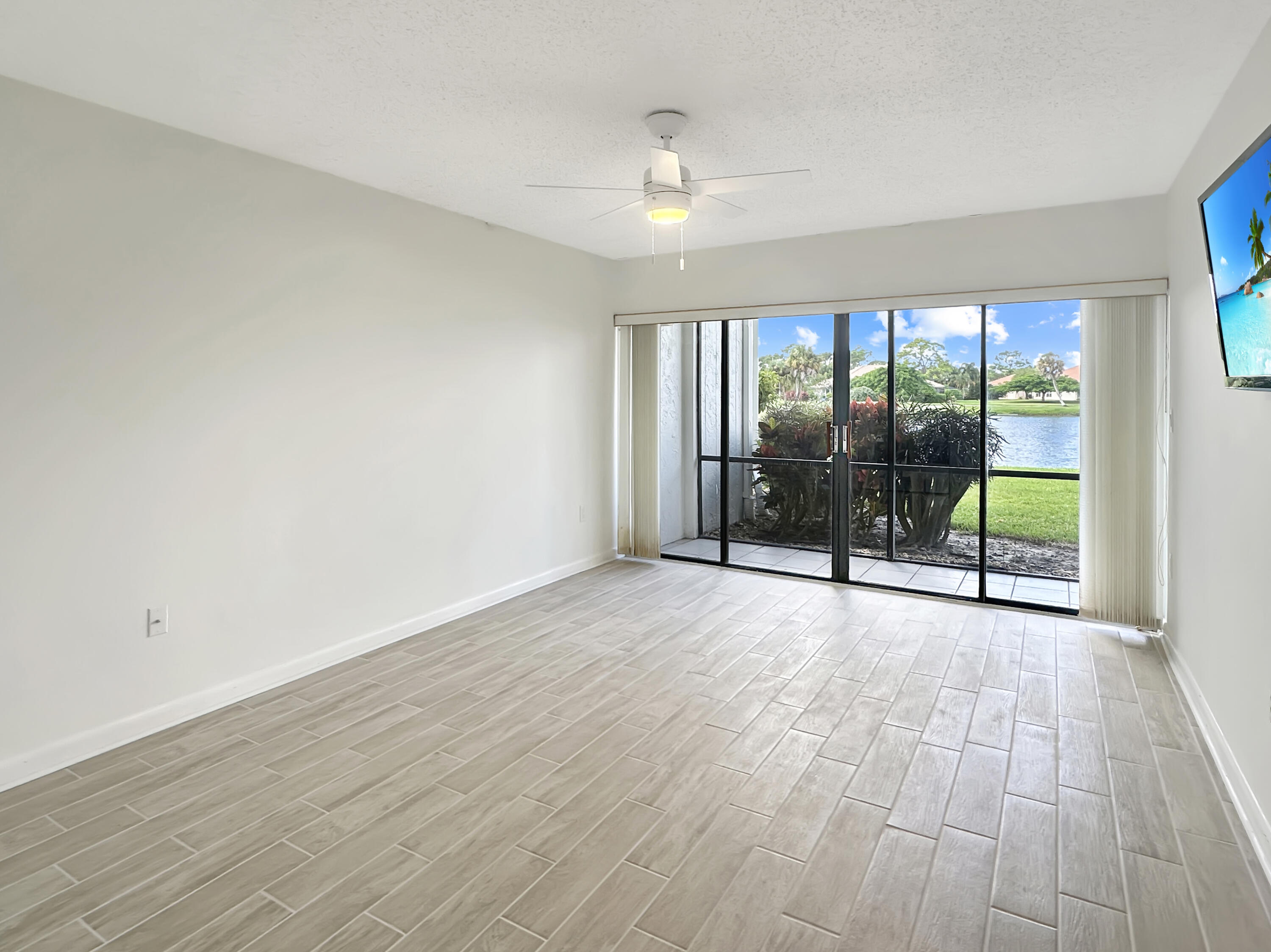 3351 Twin Lakes Terrace, Unit 102 Fort Pierce, FL 34951 - Photo 11 of 21 a view of an empty room with wooden floor and a window