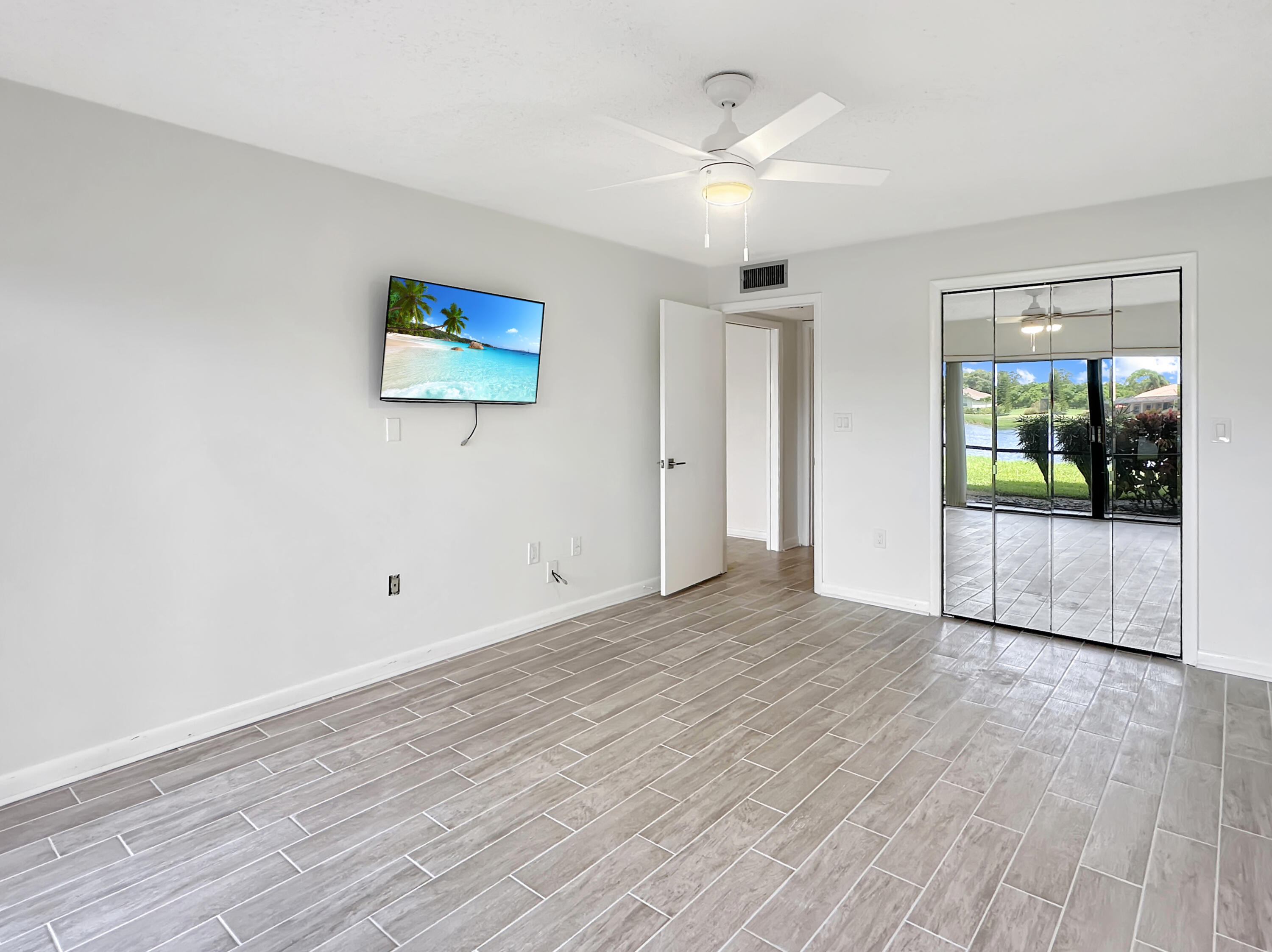 3351 Twin Lakes Terrace, Unit 102 Fort Pierce, FL 34951 - Photo 12 of 21 wooden floor in an empty room with a window
