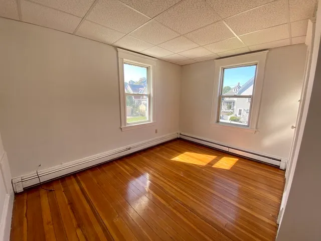 a view of a room with wooden floor and window