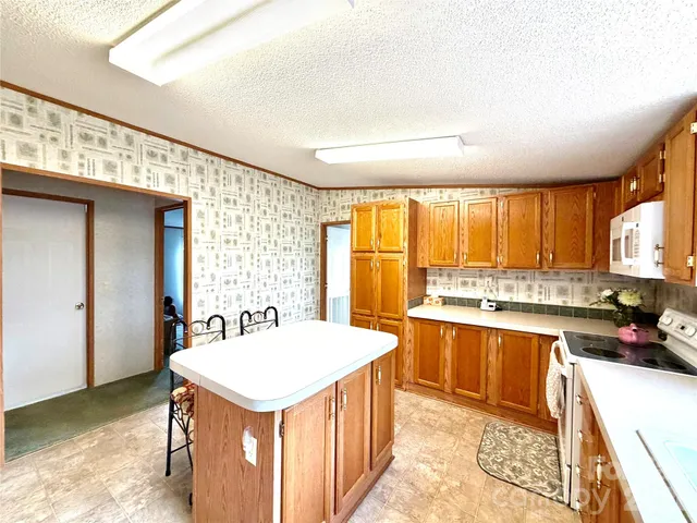 a large white kitchen with a sink stove and refrigerator