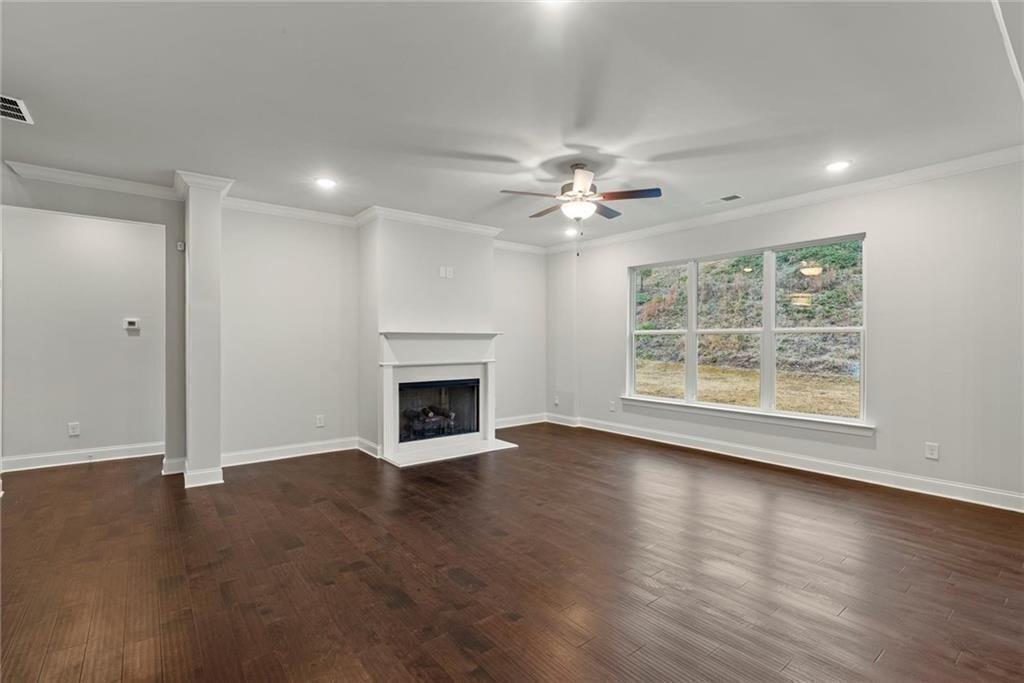 3455 Spring Pl Court Loganville, GA 30052 - Photo 12 of 42 an empty room with windows chandelier and fireplace