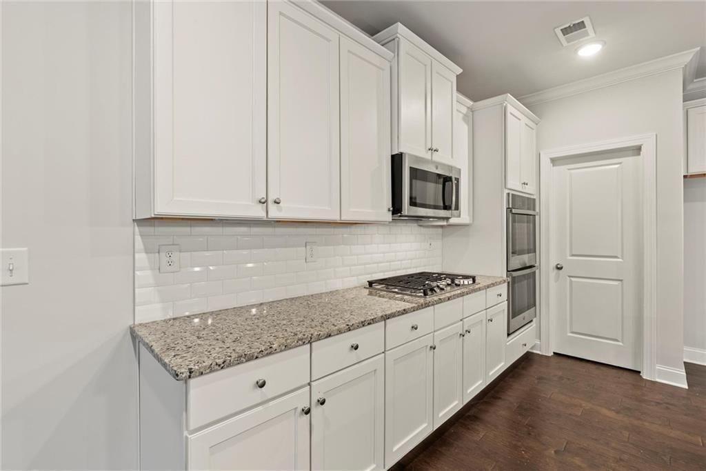 3455 Spring Pl Court Loganville, GA 30052 - Photo 18 of 42 a kitchen with granite countertop a stove sink and cabinets