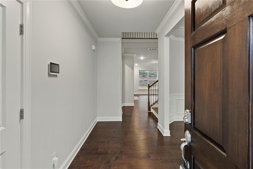 3455 Spring Pl Court Loganville, GA 30052 - Photo 3 of 42 a hallway with wooden floor chandelier and entryway