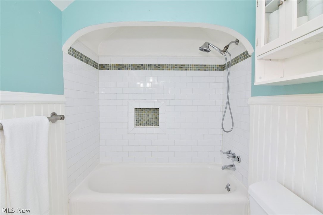 3451 Edison Road Cleveland Heights, OH 44121 - Photo 32 of 46 Bathtub with subway tile surround, mosaic accent tile, an arched shower alcove, and a built-in shower niche