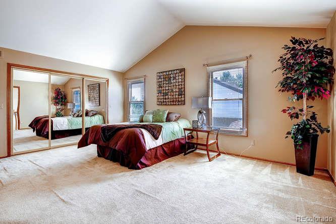 8205 Sweet Water Road Lone Tree, CO 80124 - Photo 15 of 33 a spacious bedroom with a bed and a potted plant