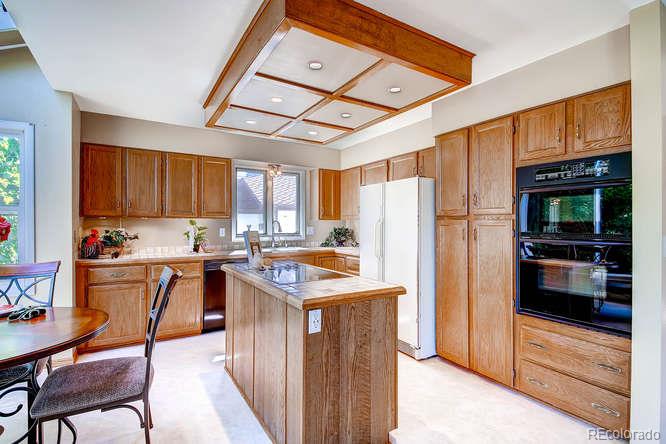8205 Sweet Water Road Lone Tree, CO 80124 - Photo 8 of 33 a kitchen with stainless steel appliances granite countertop a refrigerator and a stove top oven