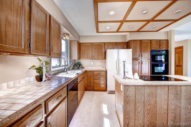 8205 Sweet Water Road Lone Tree, CO 80124 - Photo 9 of 33 a kitchen with granite countertop a sink a counter space cabinets and stainless steel appliances