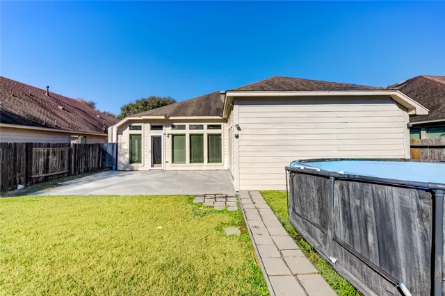 a view of a house with pool and wooden fence