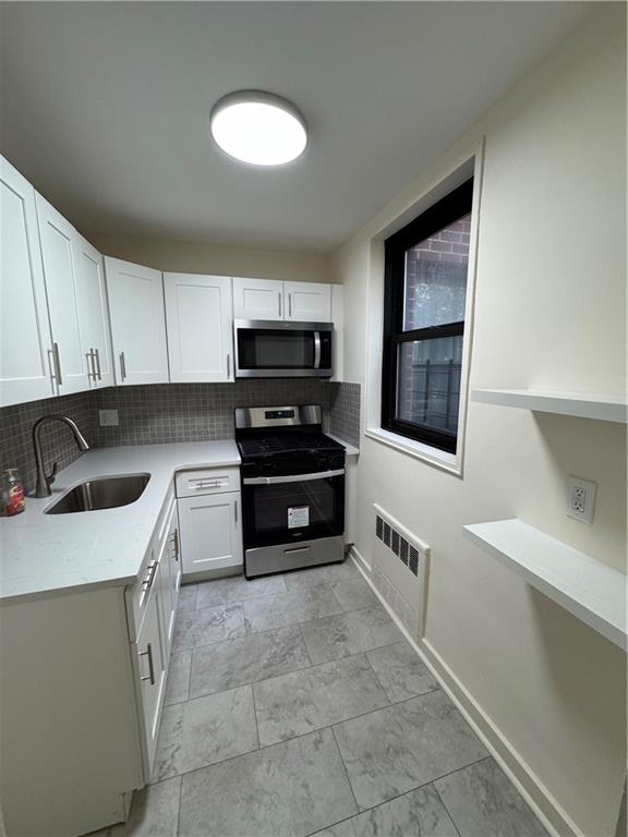 1165 East 54th Street, Unit 2Z Brooklyn, NY 11234 - Photo 11 of 14 a kitchen with stainless steel appliances a stove sink and cabinets