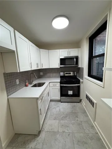 a kitchen with stainless steel appliances a stove sink and cabinets